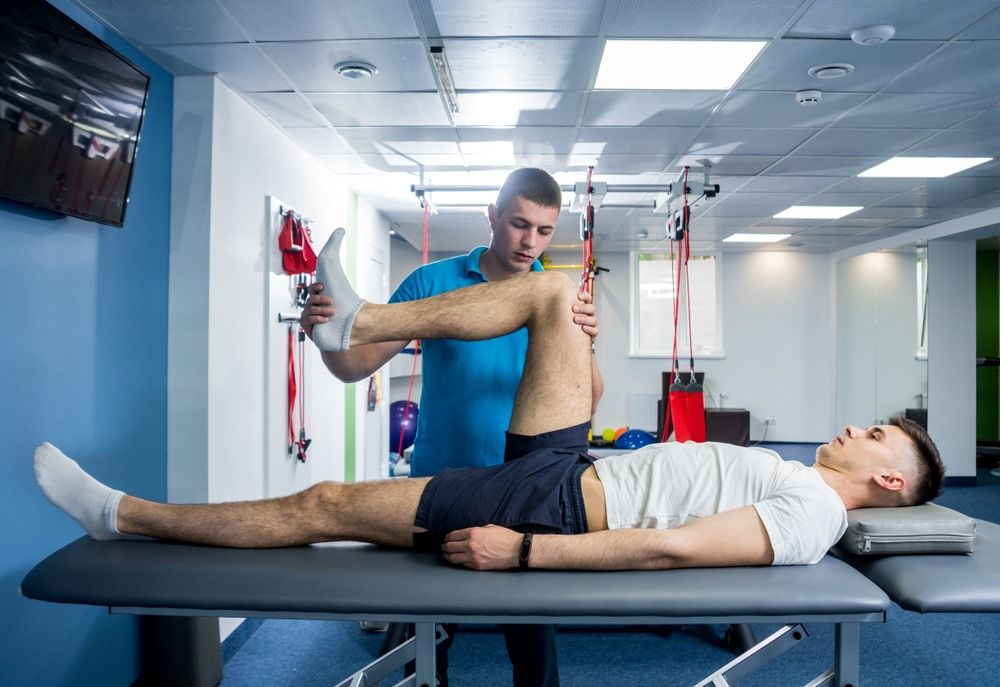 A Physical Therapist Assesses a Patient's Leg Flexibility — Axis Chiropractic In Cairns City, QLD
