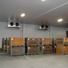 a large cold storage warehouse filled with lots of wooden crates .