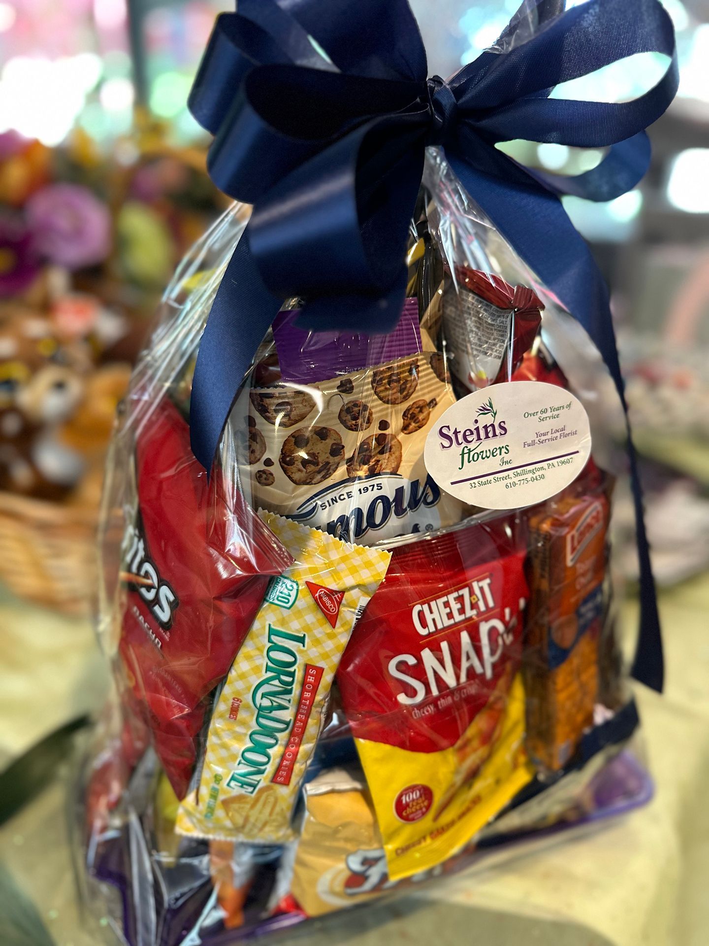 A bag of snacks with a blue bow is sitting on a table.