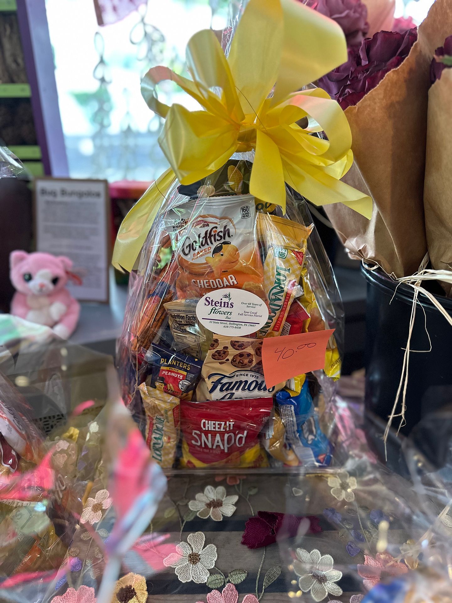 A basket filled with candy and snacks is sitting on a table.