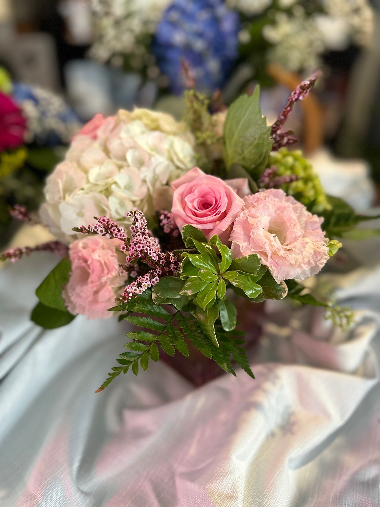 A vase filled with pink and white flowers is sitting on a table.