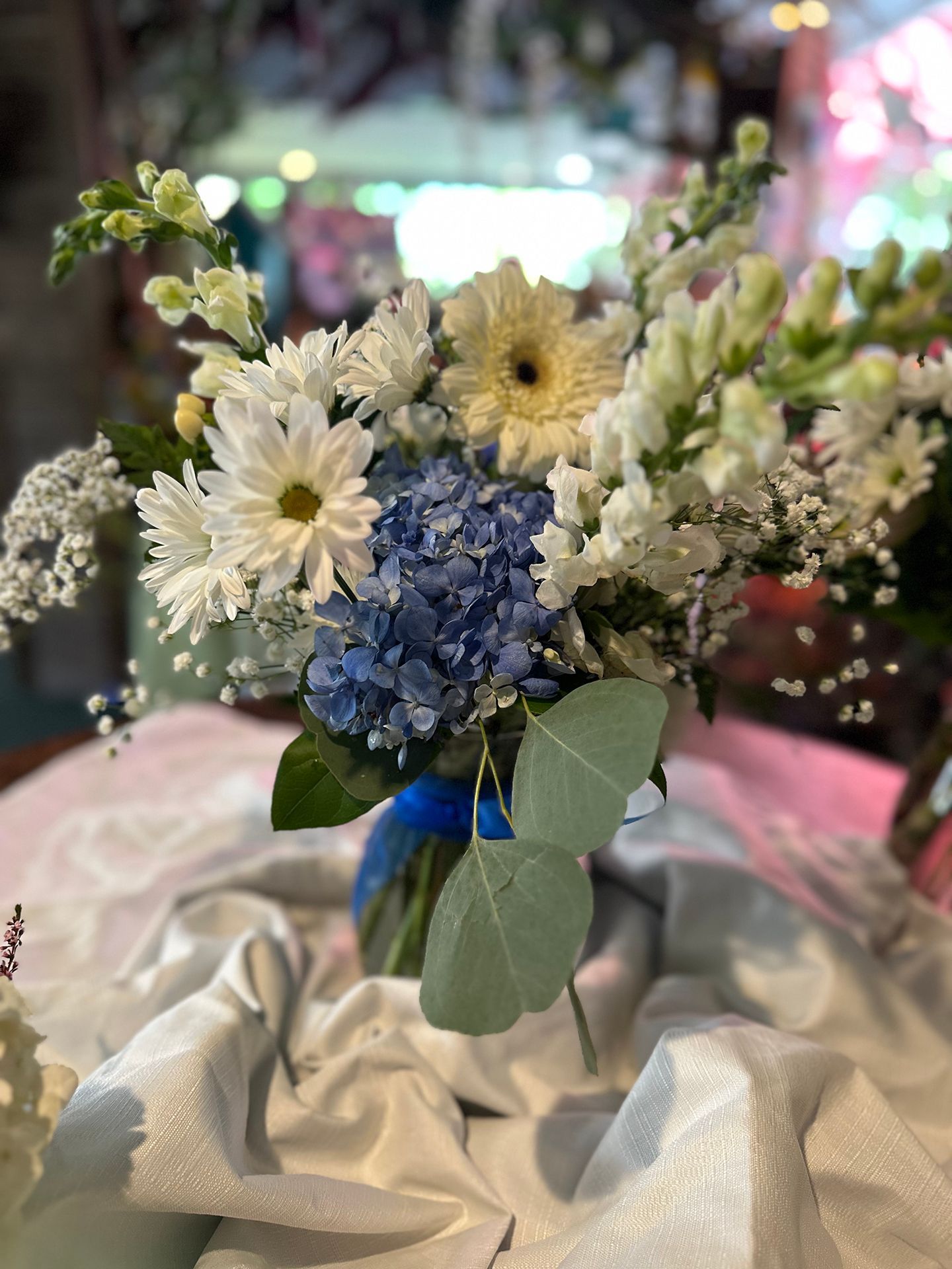 A vase filled with blue and white flowers is sitting on a table.