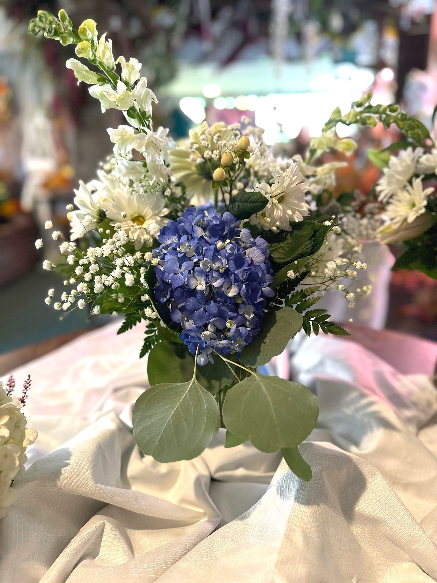 A vase filled with pink and blue flowers is sitting on a table.