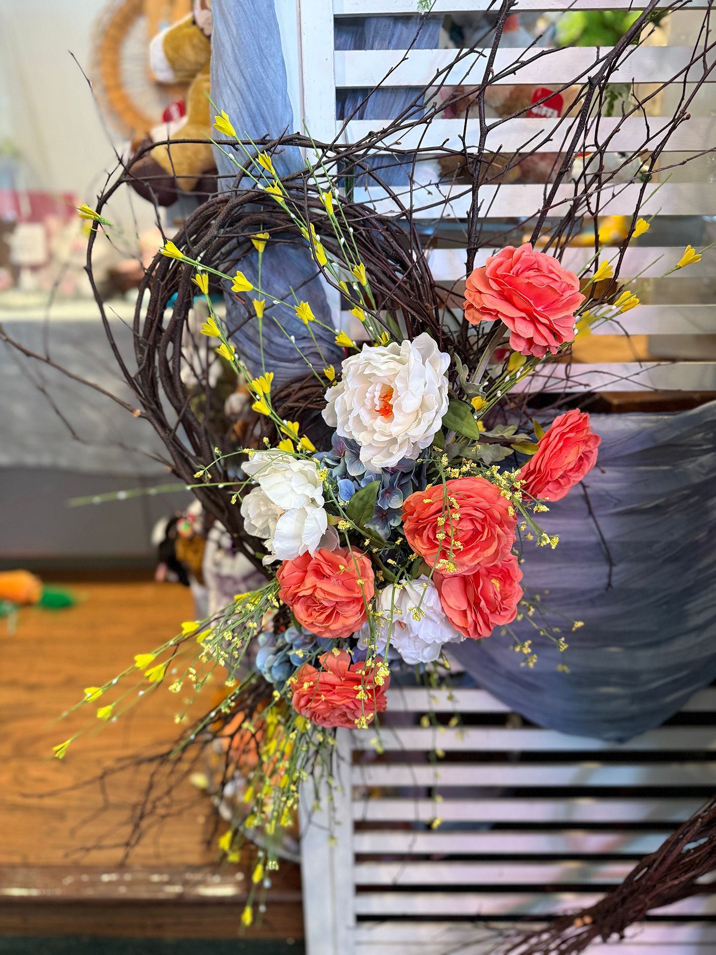 A vase filled with flowers and a wooden bunny on a table.