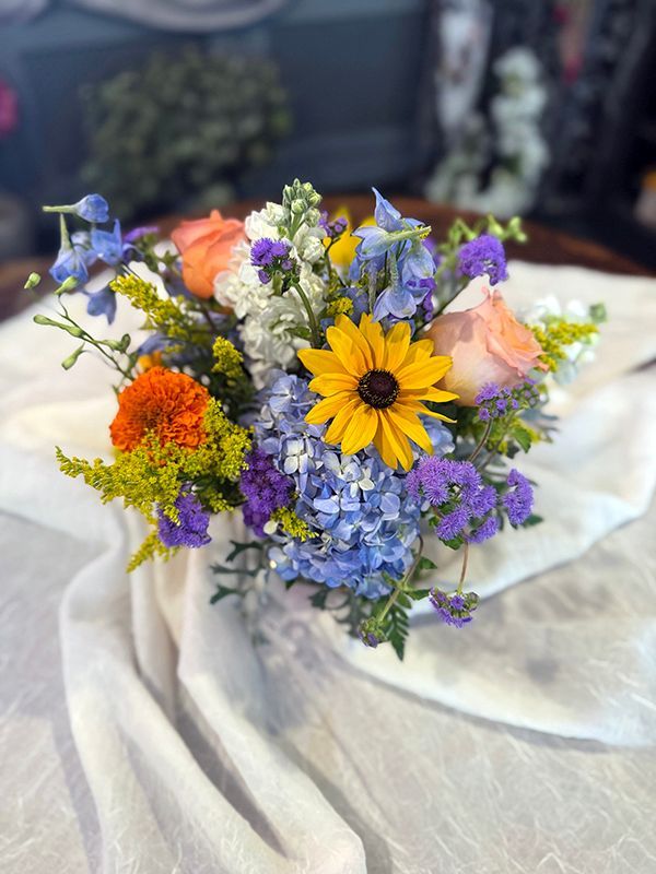 A vase filled with colorful flowers is sitting on a table.