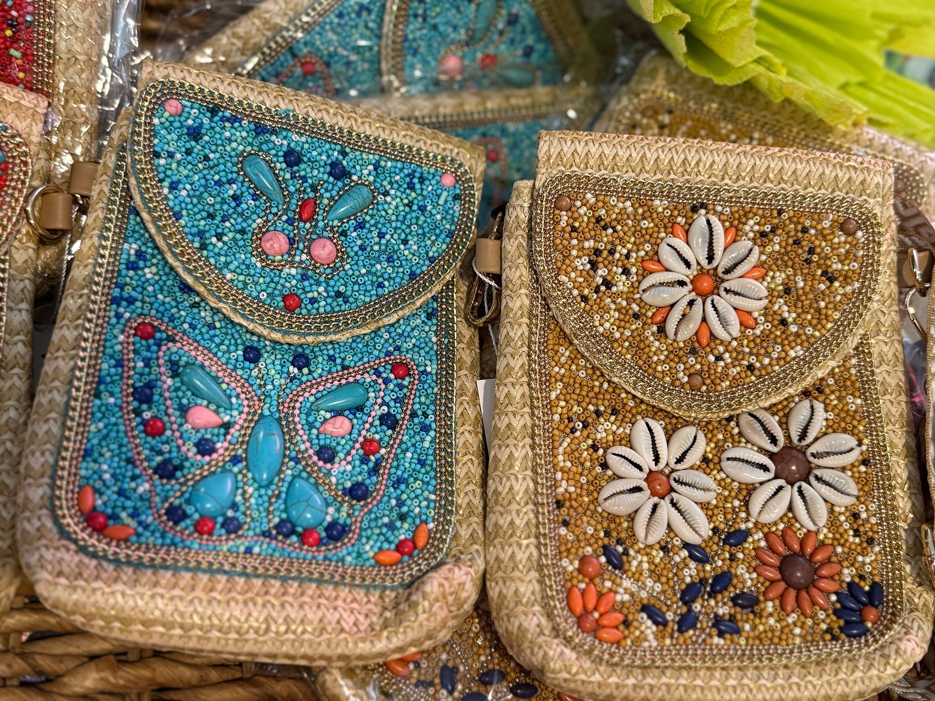 blue and gold beaded shoulder bags with flower and butterfly decorations on them laying next to each other