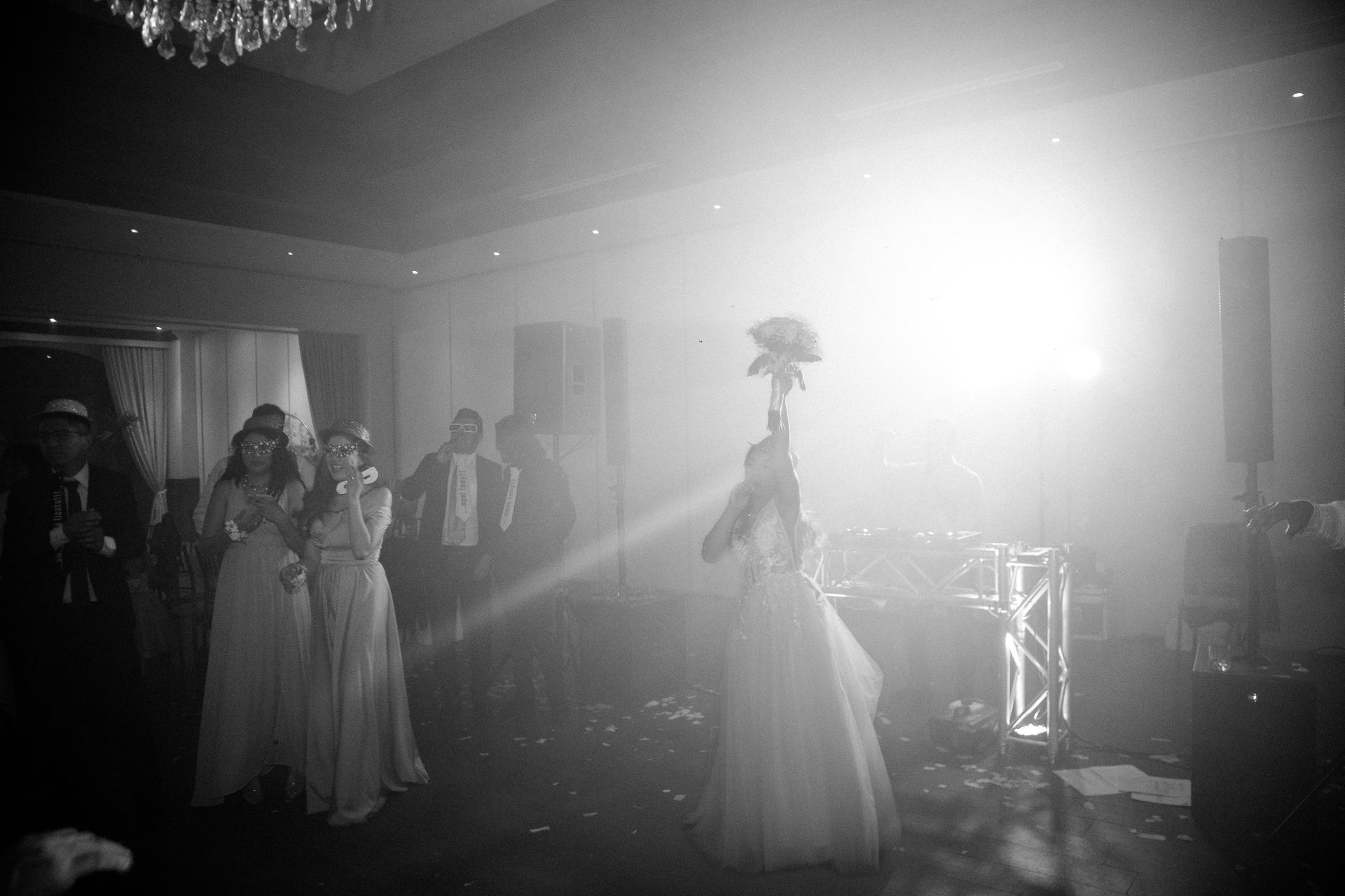 High-Energy Wedding Reception Party with Bride Tossing Flowers, Supported by Professional Sound System and Dynamic Event Lighting.