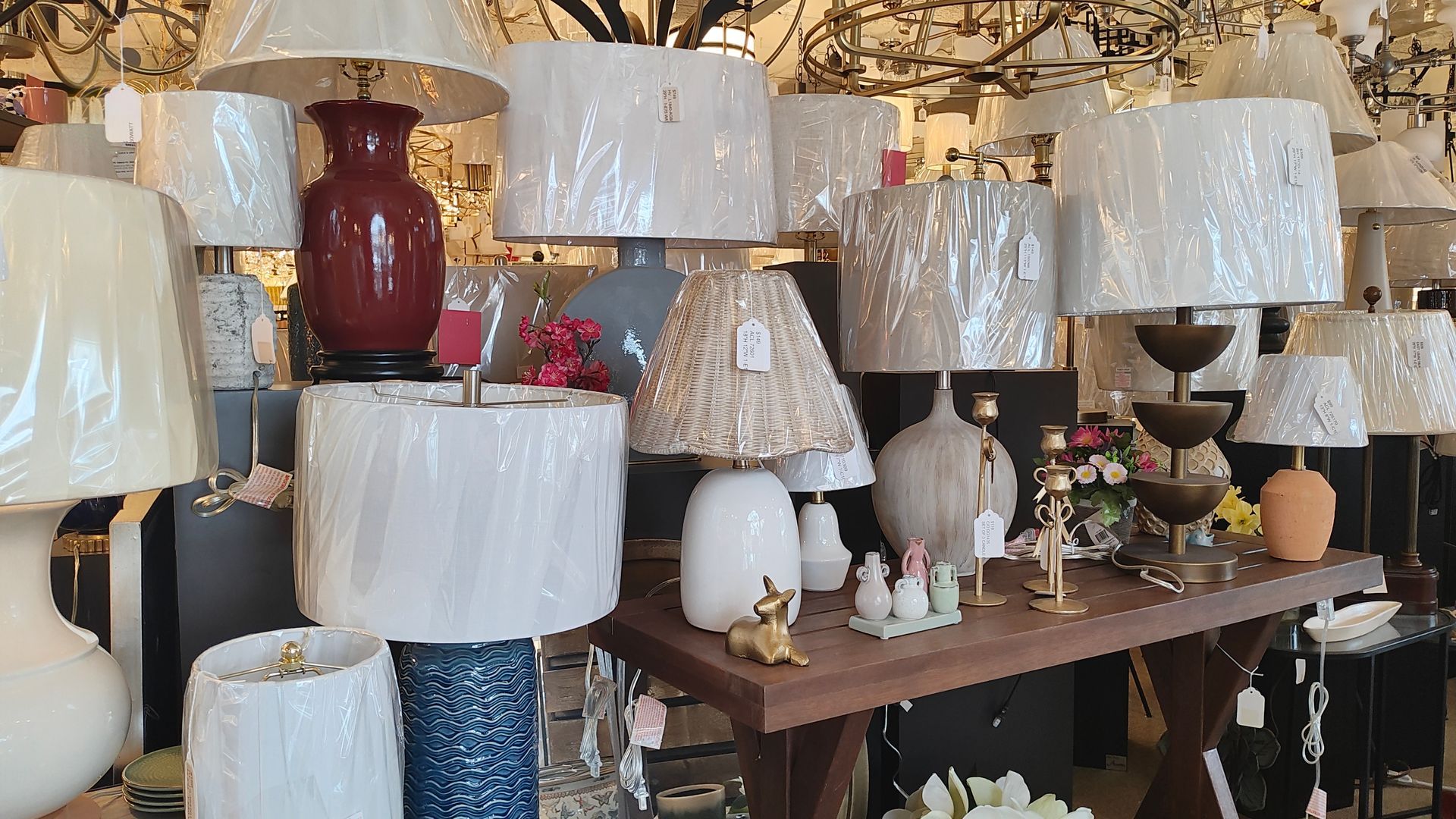 Table lamp display with many lampshades in white, beige, and gold in a shop showroom. Avon, CT