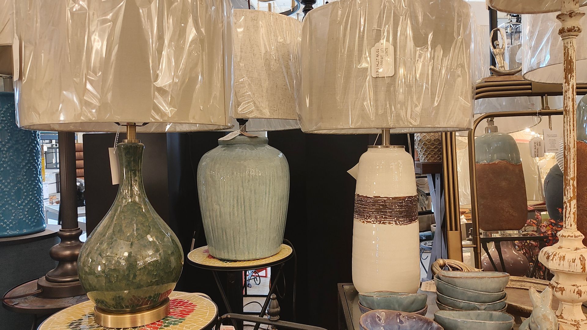 Assorted decorative lamps and ceramic vases displayed on shelves in a store in Avon, CT.