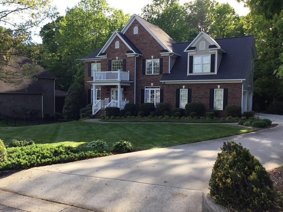 Wide green lawn mowed in straight lines beside mature trees on a Catawba County property