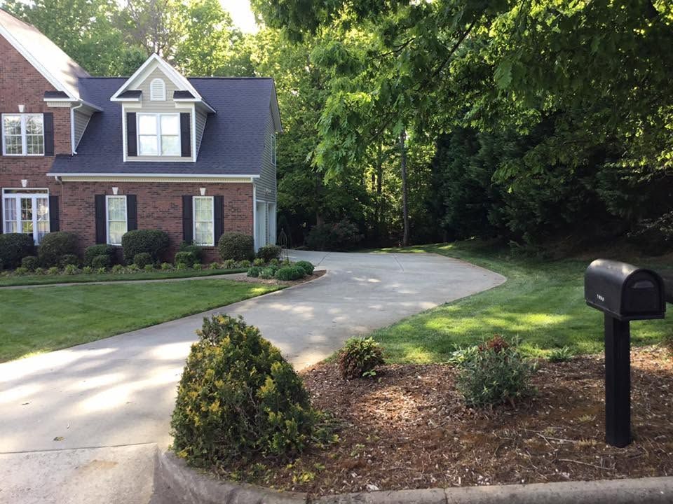 Mowed front lawn with edged walkway and seasonal plantings on a Catawba County property