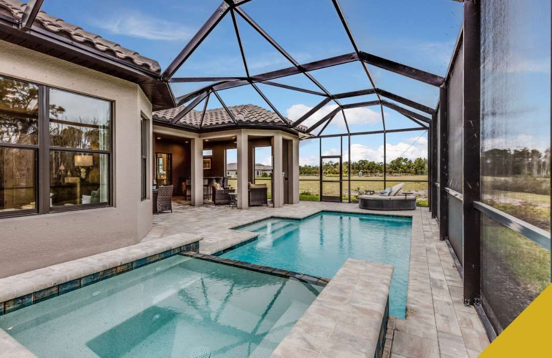 Outdoor pool and spa enclosed by screened structure; tan house.
