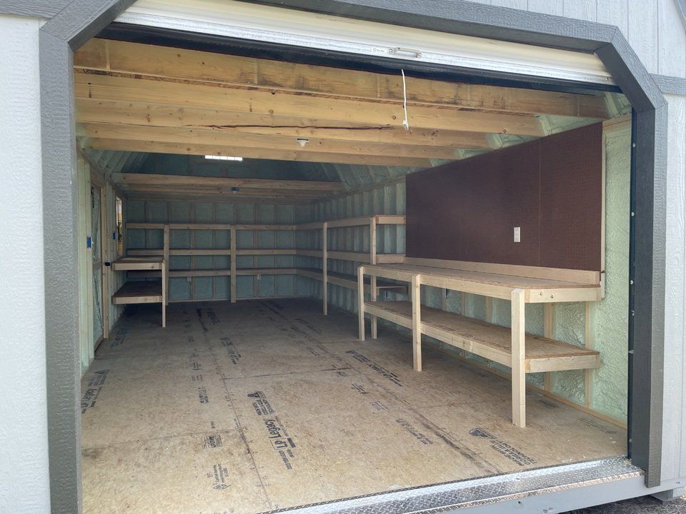The interior view of a garage with shelves and a peg board.