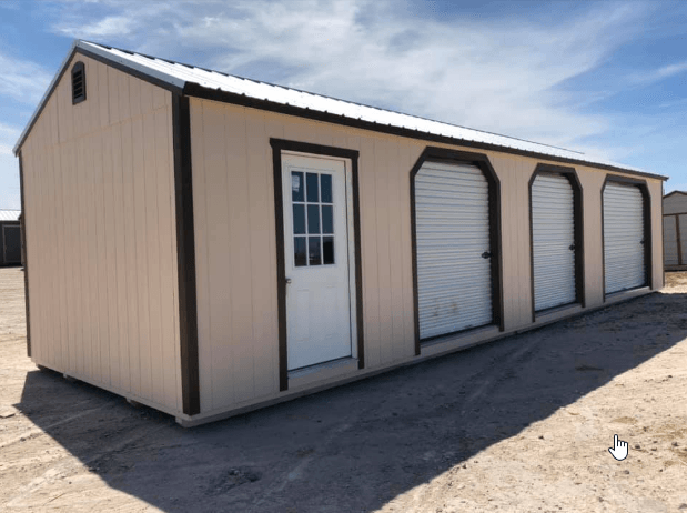A tan shed with white garage doors and a window