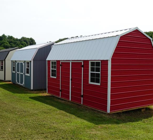 A metal and wood side lofted barn side by side.
