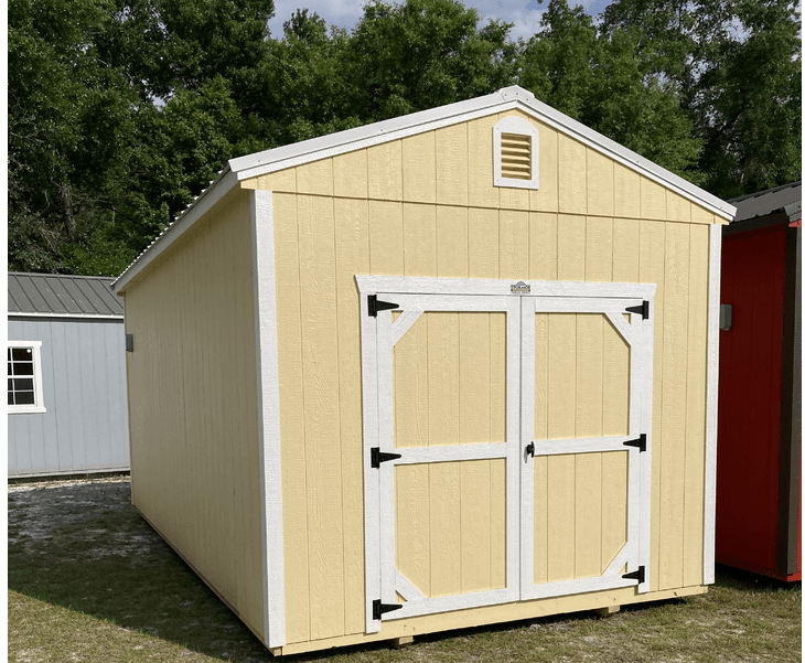 A yellow shed with white doors is sitting in the grass