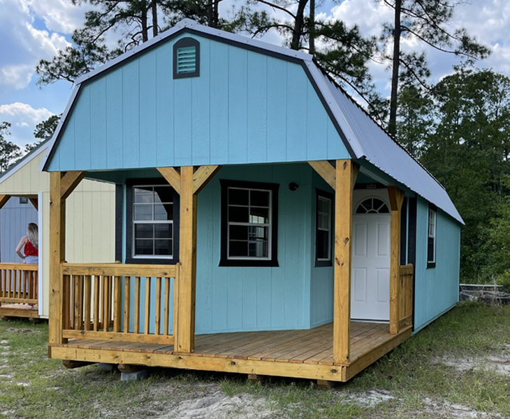 A blue barn with a porch and a white door