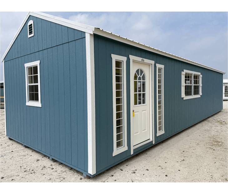 A blue shed with white trim and windows