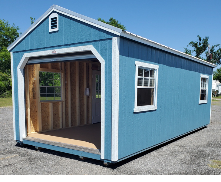A blue shed with a garage door and windows