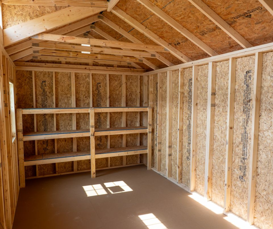 Unfinished wooden shed interior with built-in shelves and sunlight on the floor