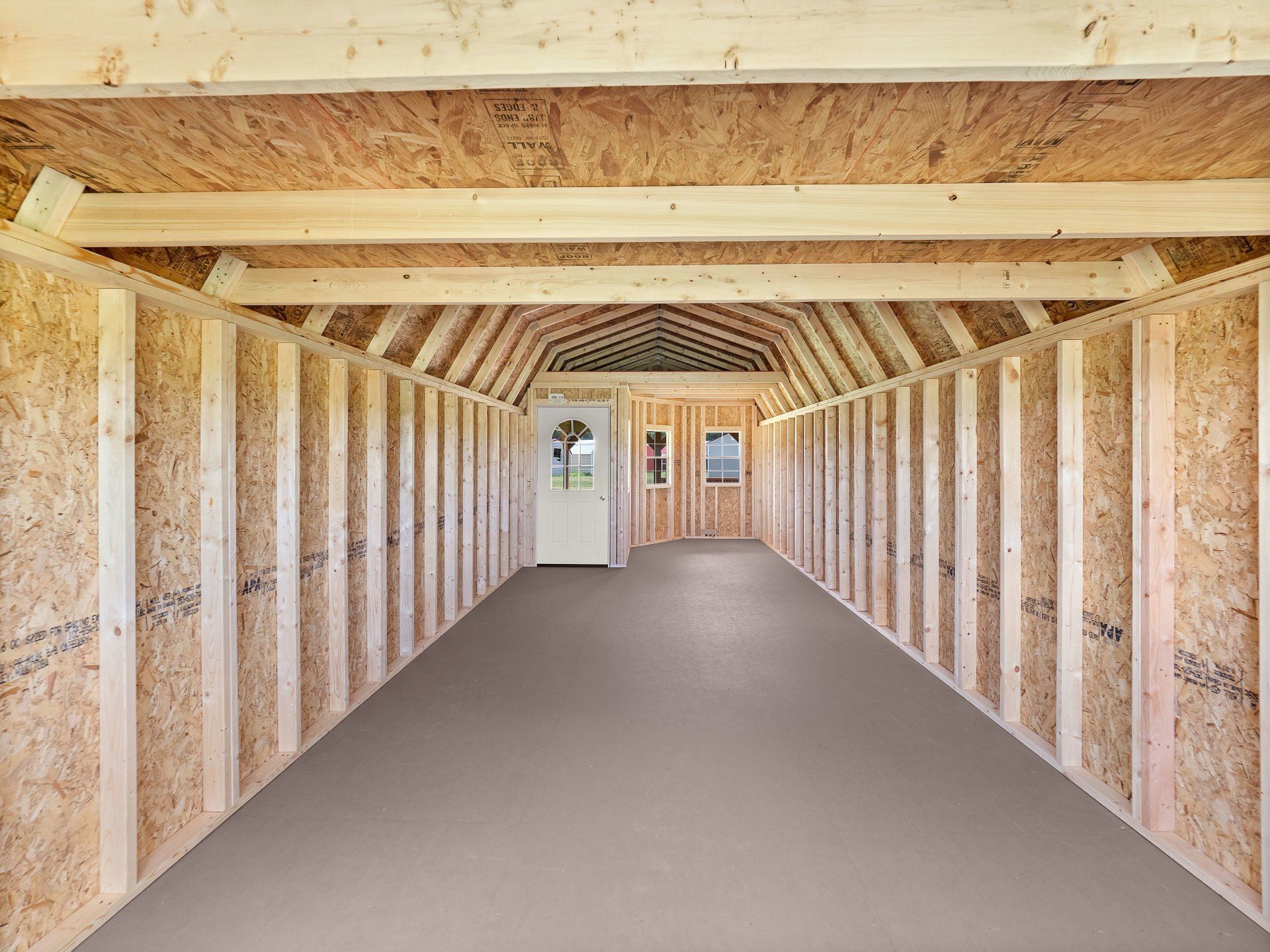 An empty Deluxe Lofted Barn Cabin with wooden walls and a tongue & groove flooring.