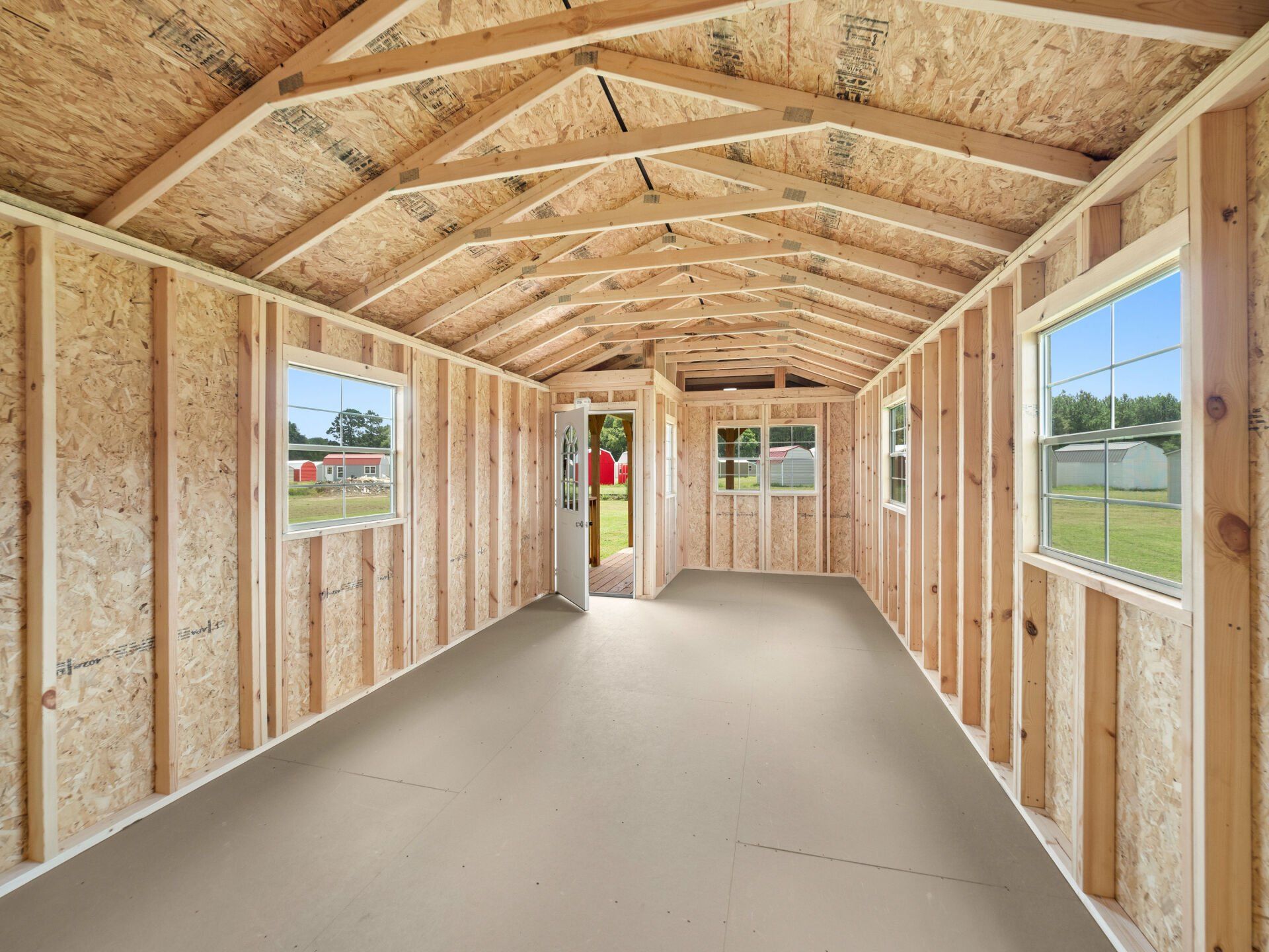 The inside of a shed with wooden walls and windows.
