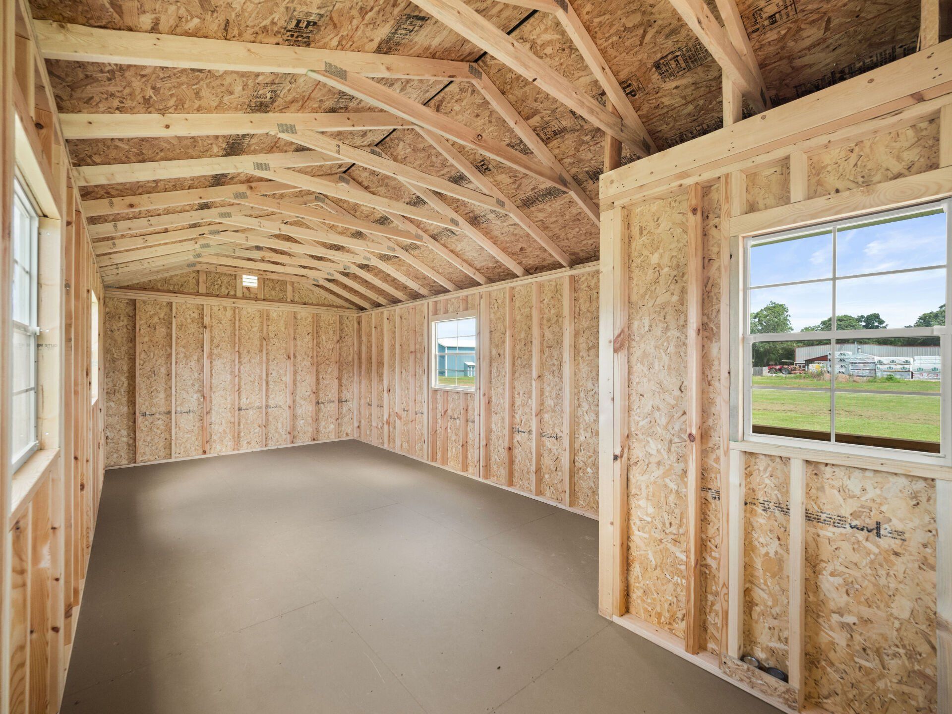 The inside of a wooden shed with a roof and windows.