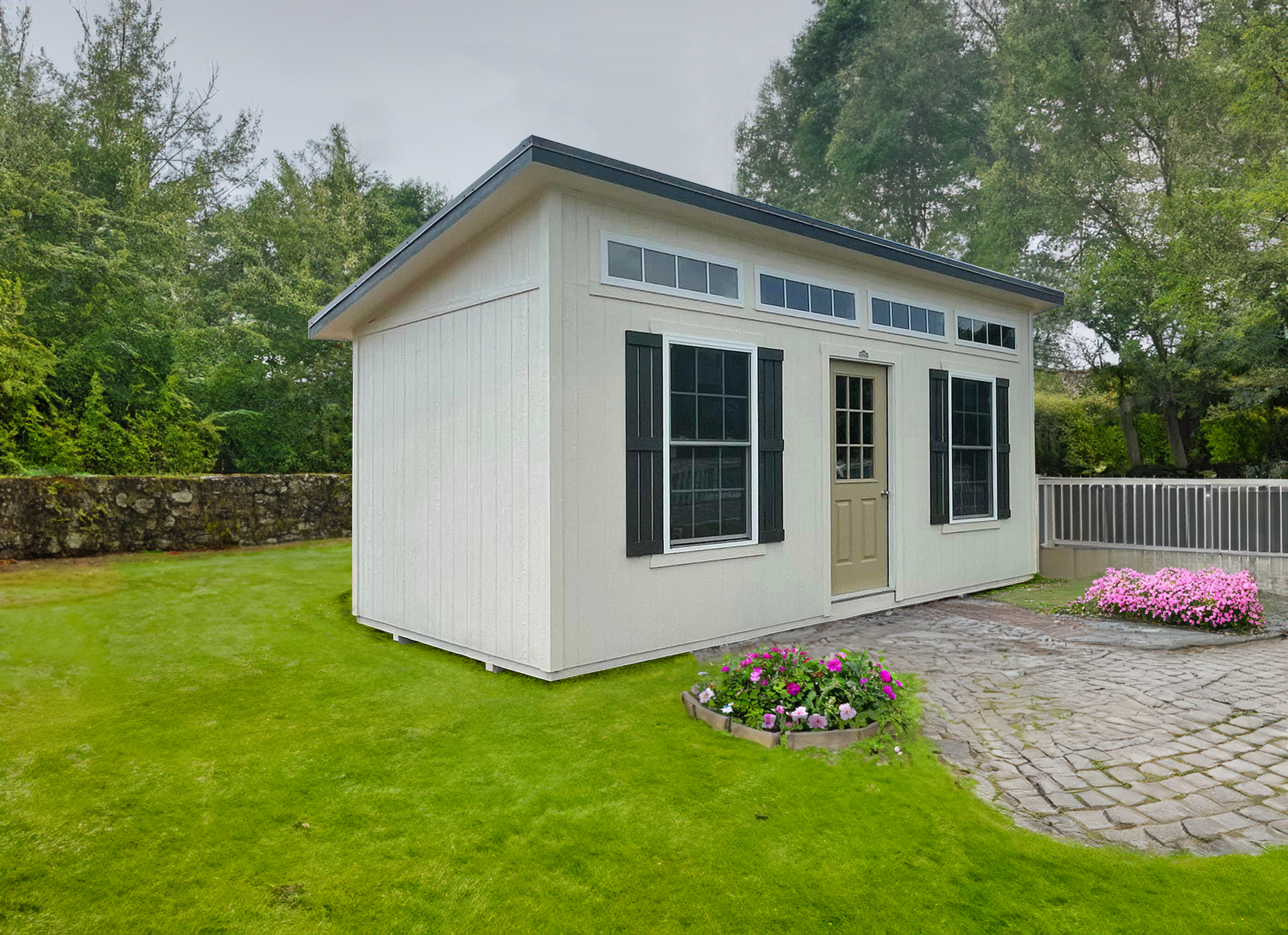A white shed with black shutters sits in the middle of a lush green yard