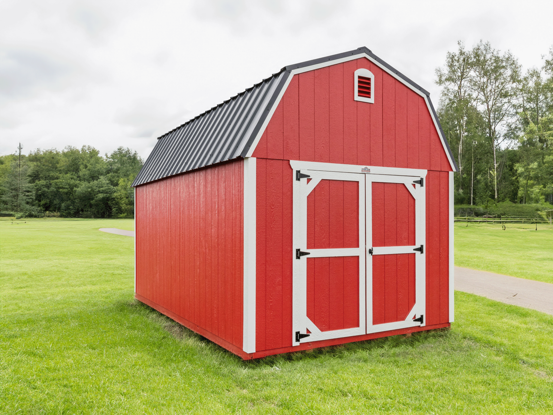Red barn-style shed with white trim on a grassy lawn