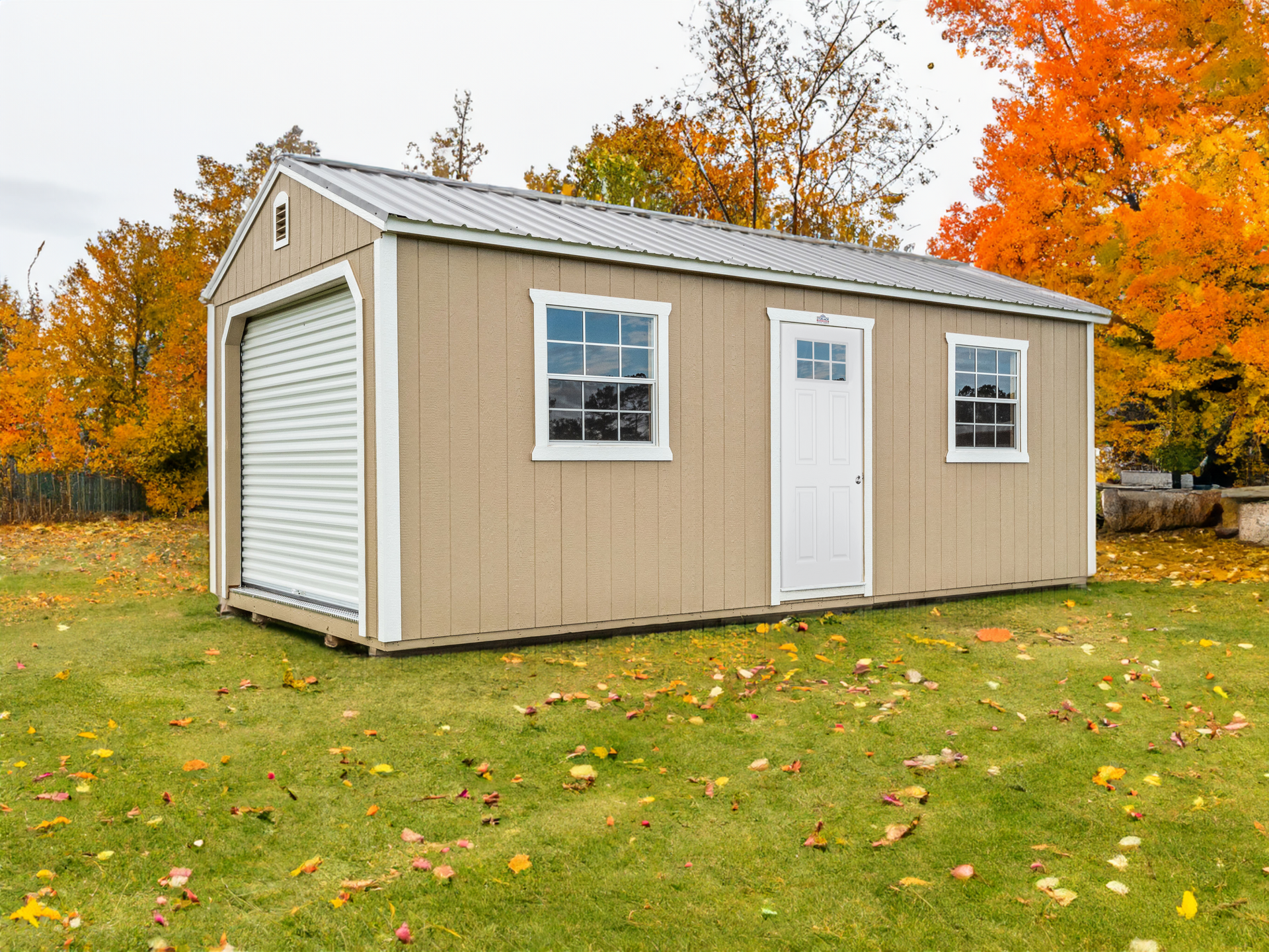 A small shed is sitting in the middle of a lush green field.
