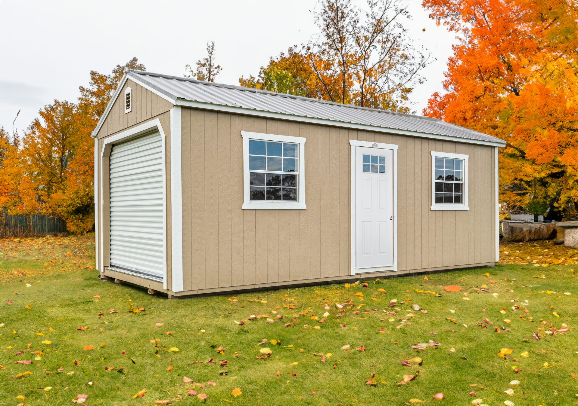 A small shed is sitting in the middle of a grassy field.
