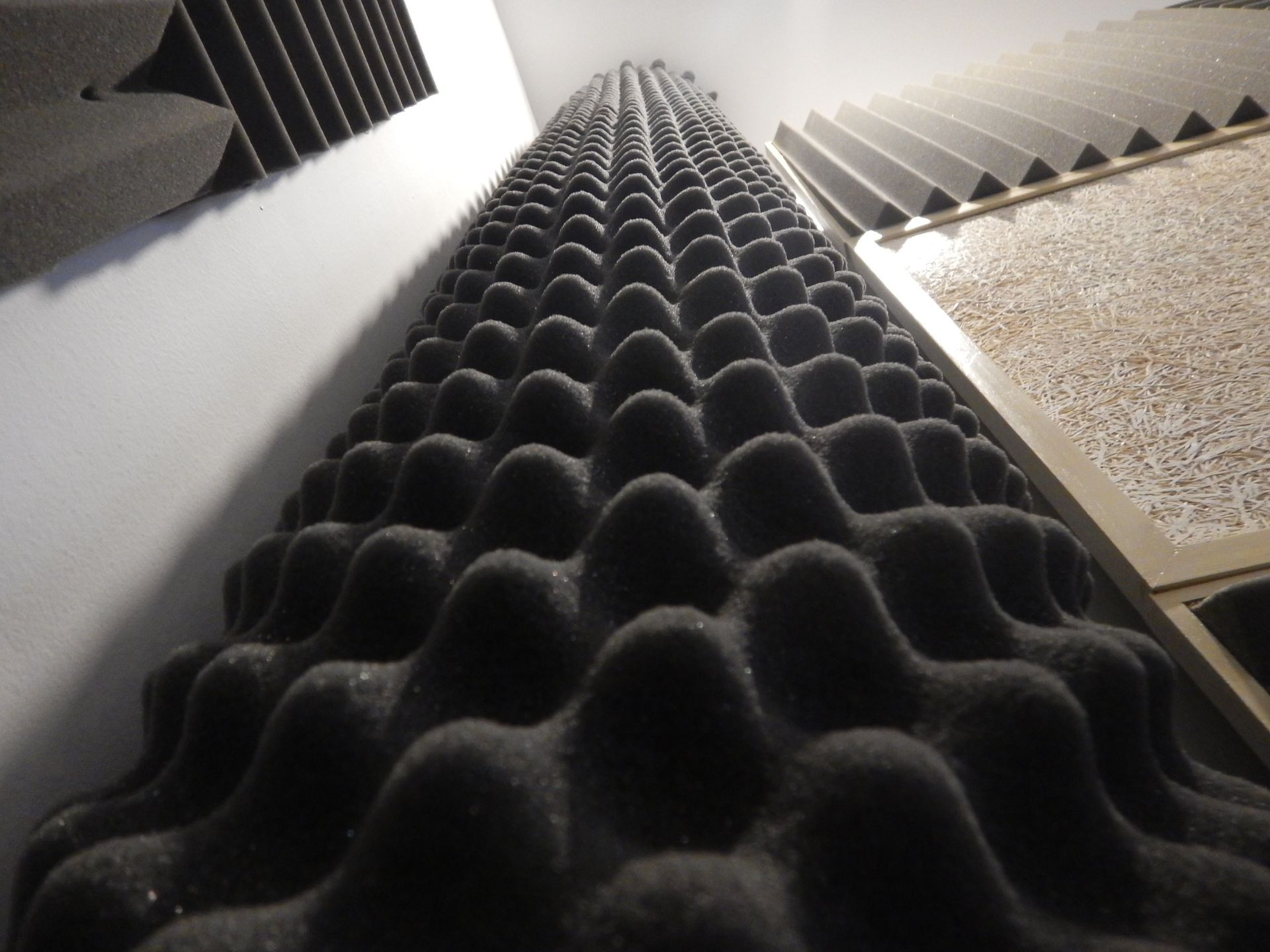 A row of black foam blocks against a white wall