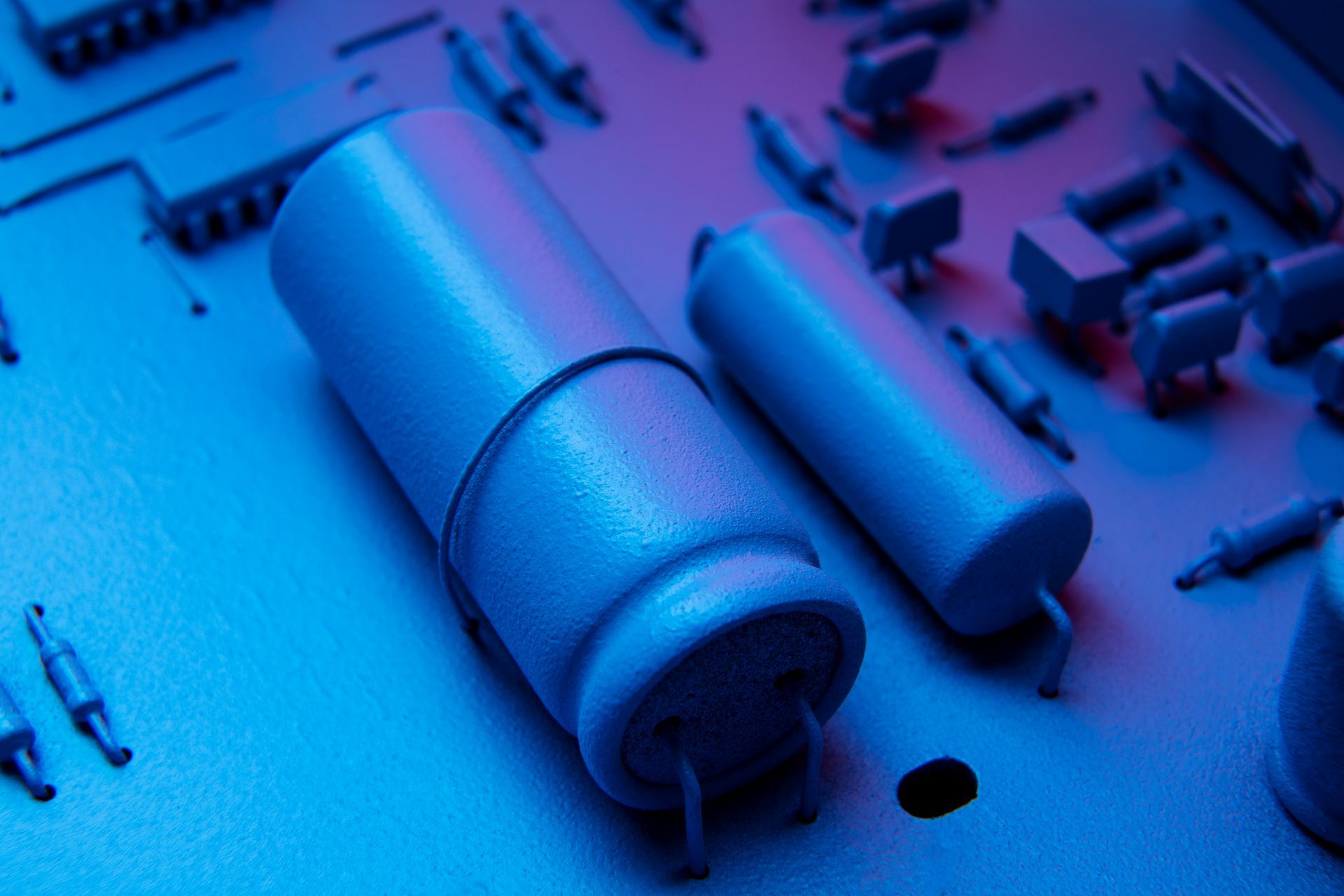 A close up of two capacitors on a motherboard.