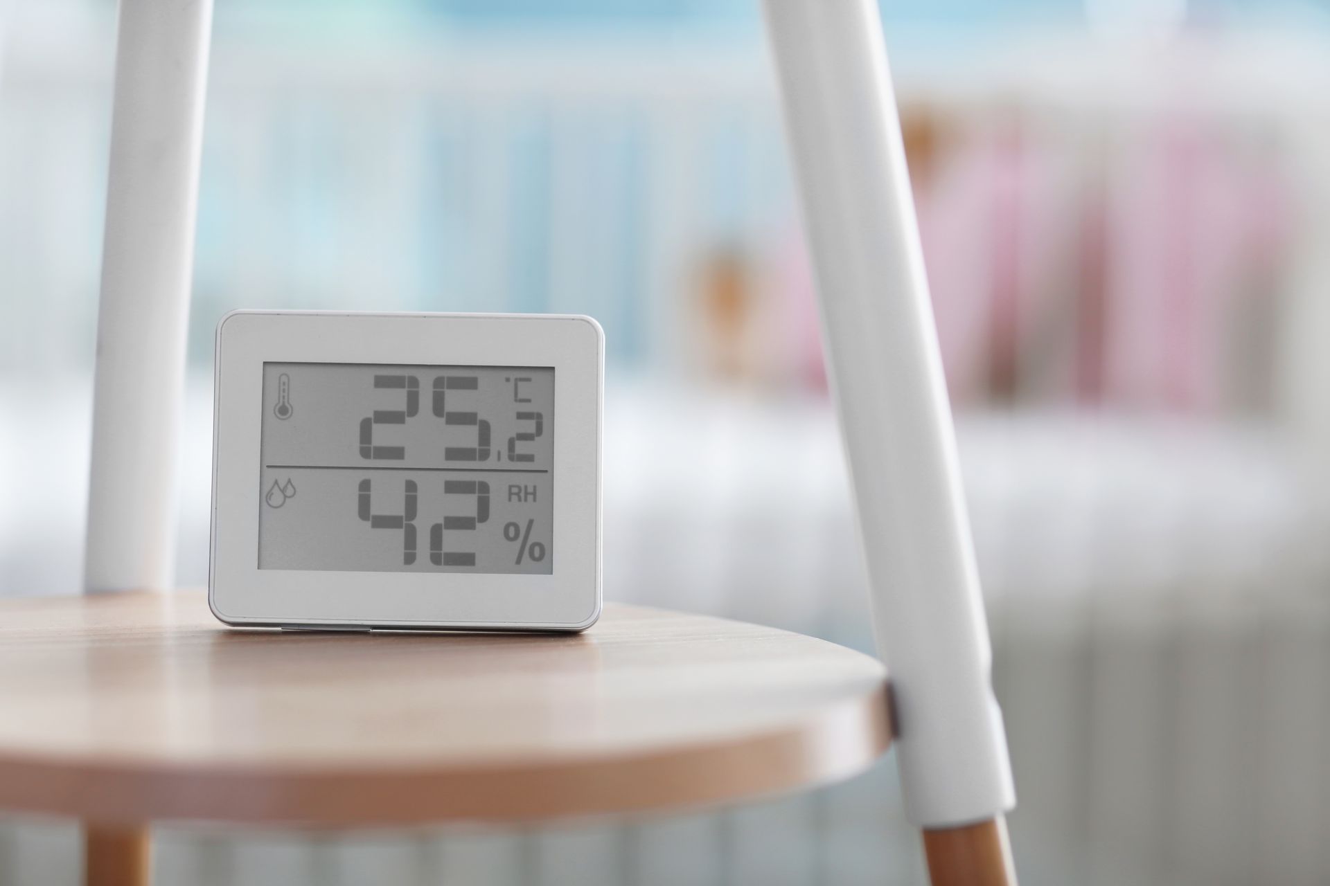 A digital thermometer is sitting on a wooden table.