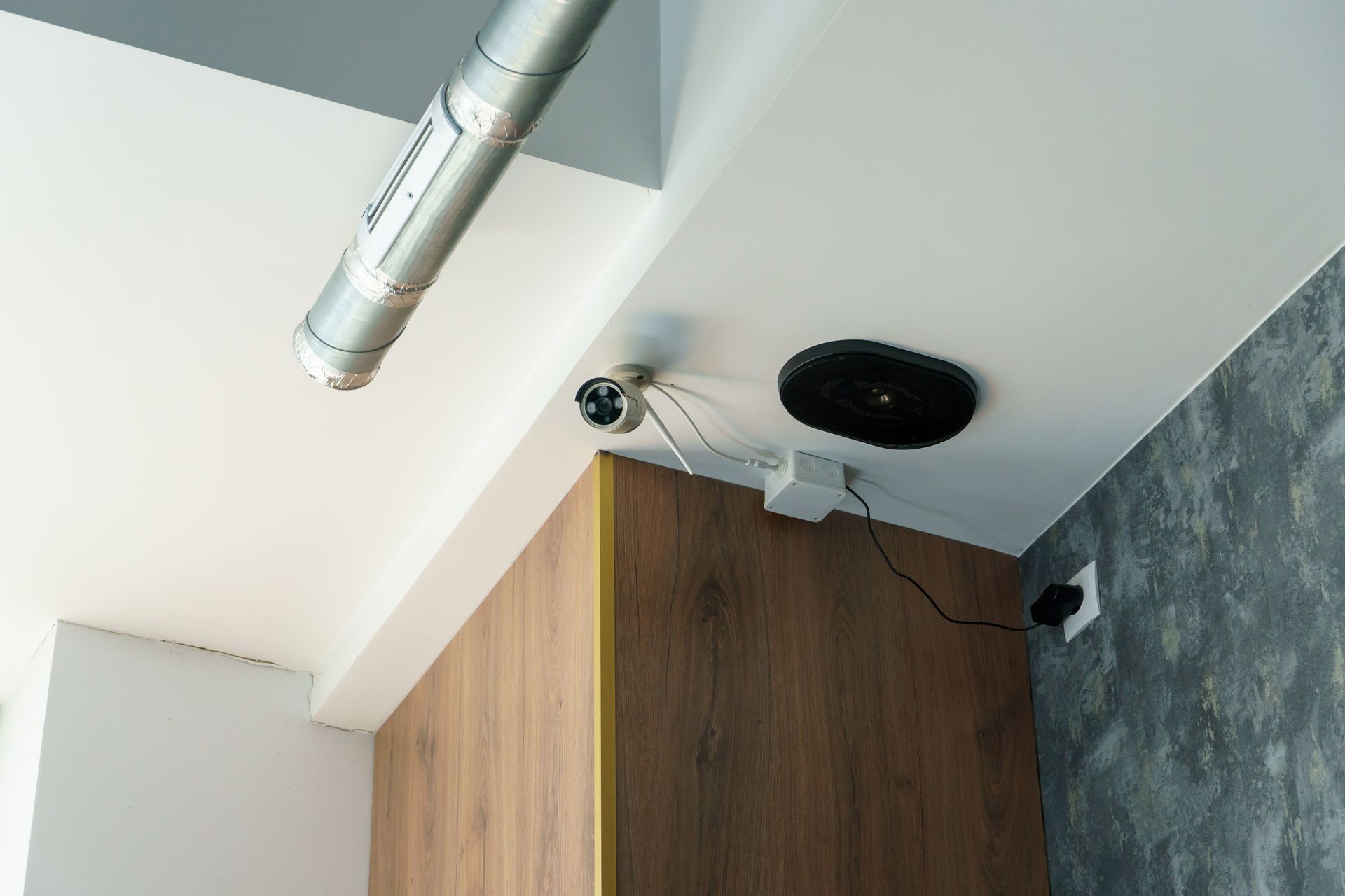 A camera is hanging from the ceiling of a room.