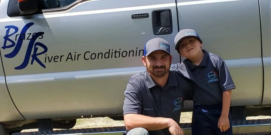 A man is fixing an air conditioner with a screwdriver.