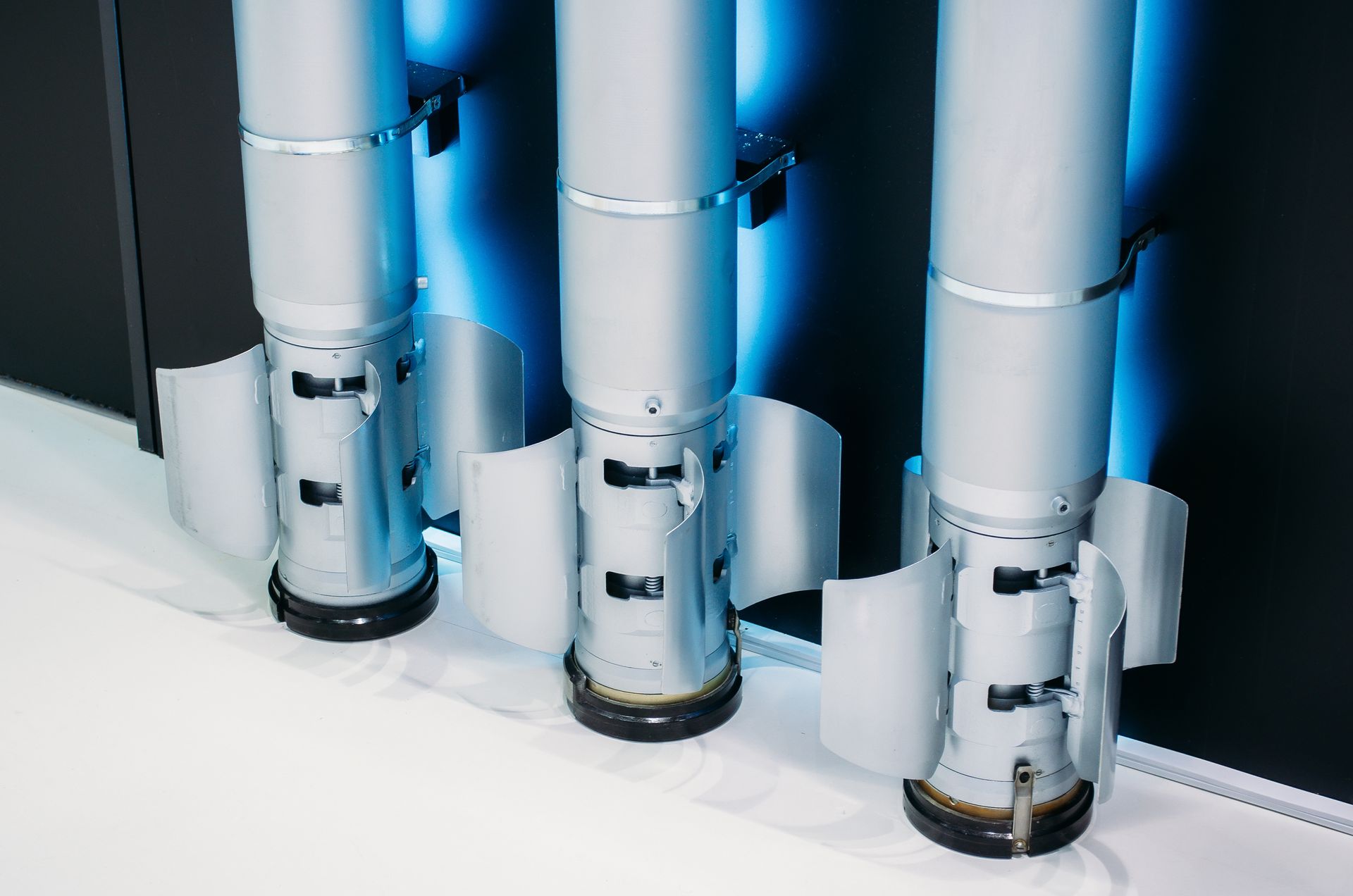 Three rockets are sitting next to each other on a white surface.