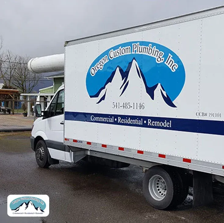 A white box truck parked outdoors featuring the logo 