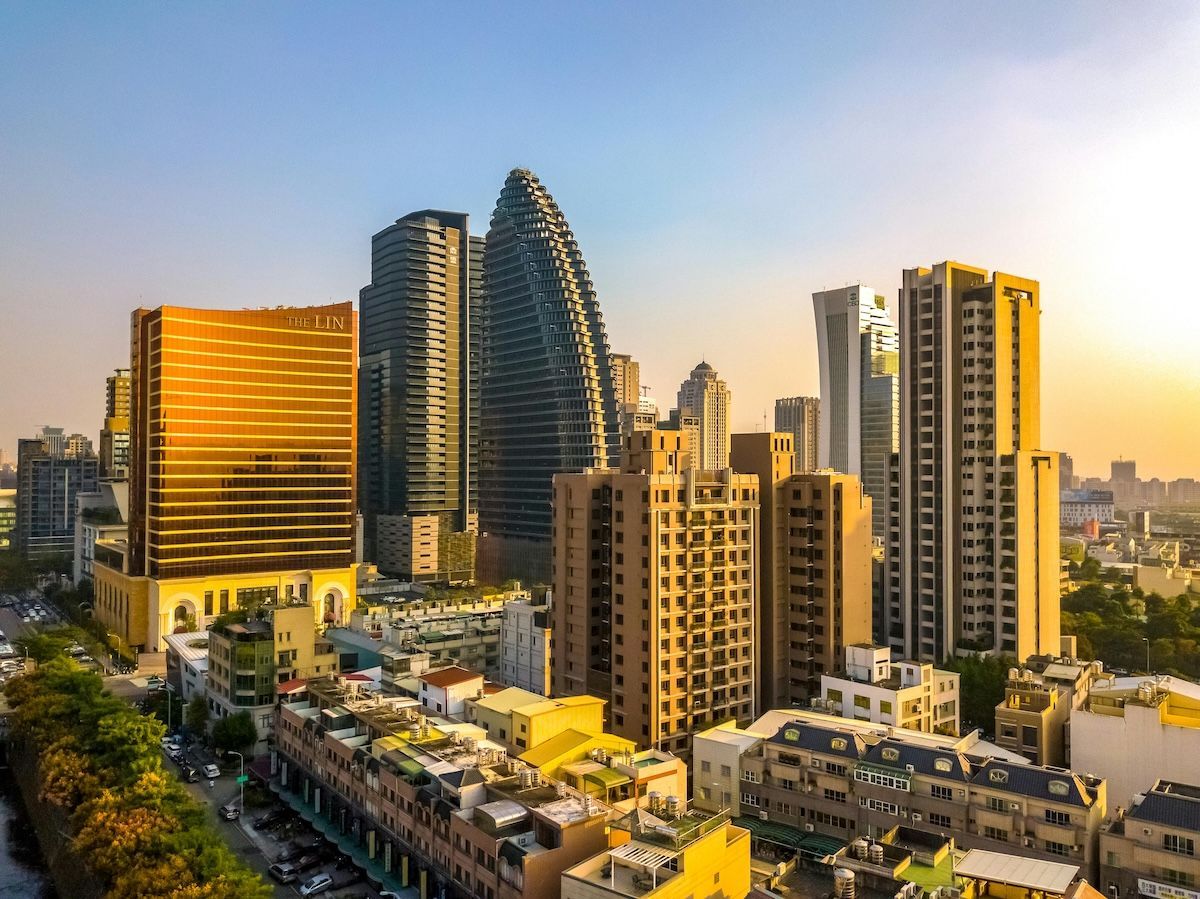 城市天際線，高聳的現代建築和溫暖的金色日出。