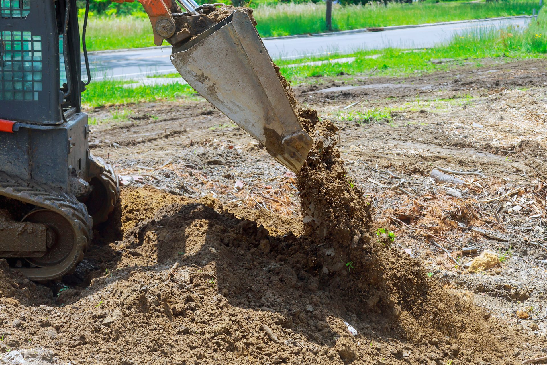 Lawn Care Maintenance A bulldozer is digging a hole in the ground.