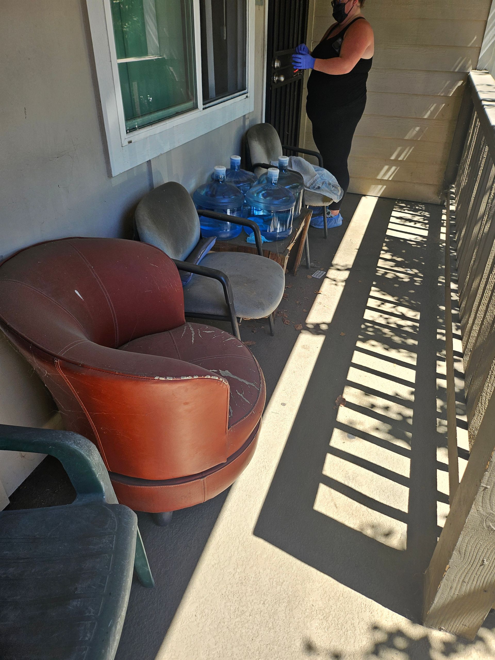 Apartment balcony with chairs, a table, and a person standing by the window
