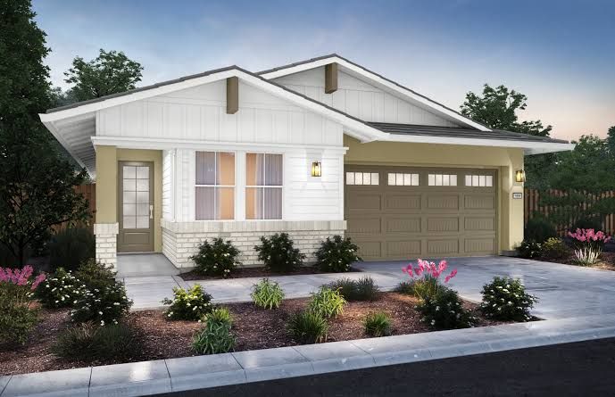 Modern white single-story house with a two-car garage, front porch, and landscaped front yard at dusk