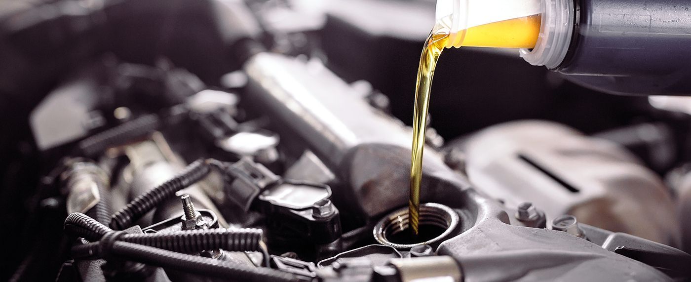 Pouring oil into a car engine.