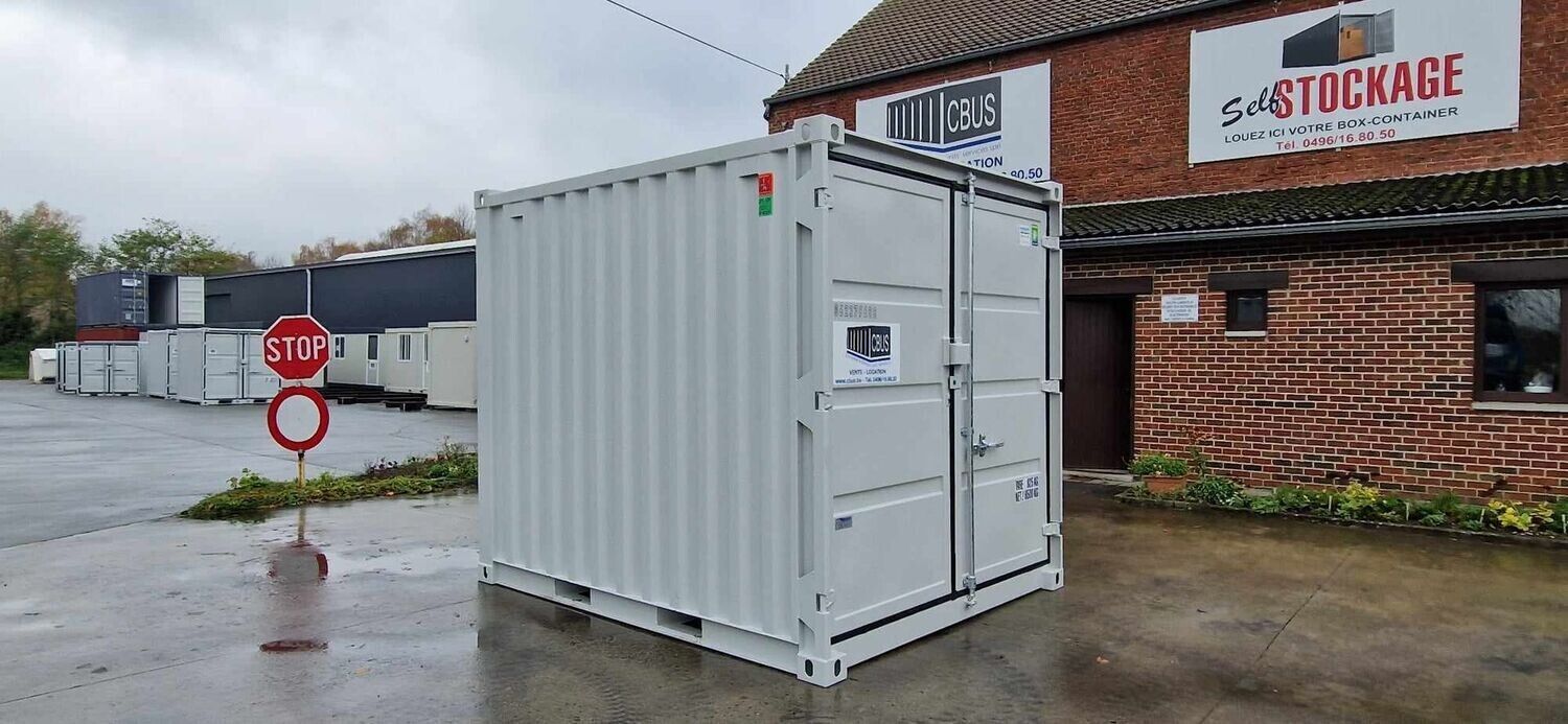 Container de stockage 10 pieds gris clair sur la cour mouillée du dépôt CBUS à Arquennes