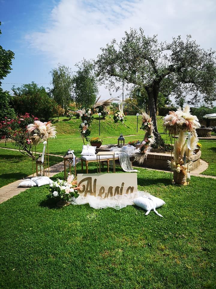 Un'area per eventi all'aperto decorata su un prato, con un cartello con la scritta