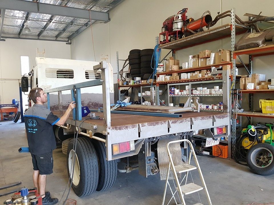 Man Working on a Truck Bed Inside a Garage With Shelving — R&B Automotive PTY LTD In Urangan, QLD