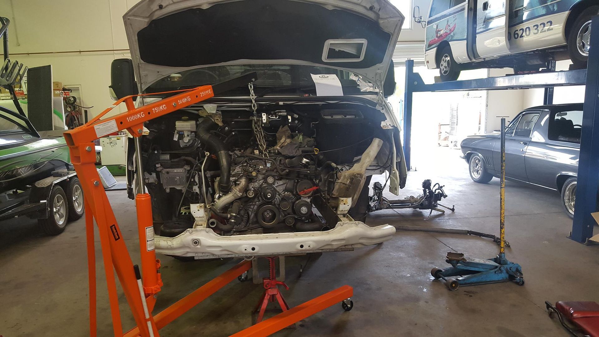 Engine Being Removed From a Vehicle in a Mechanic's Shop, Orange Lift Crane — R&B Automotive PTY LTD In Urangan, QLD