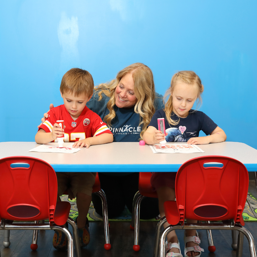 A preschool teacher helping her students in class.