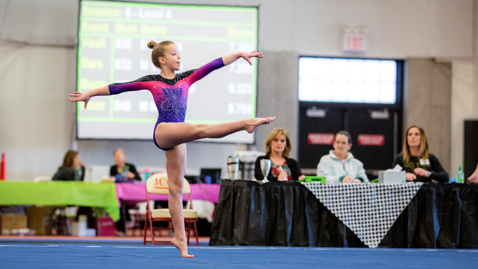 A young gymnast performing a floor routine at her first gymnastics meet