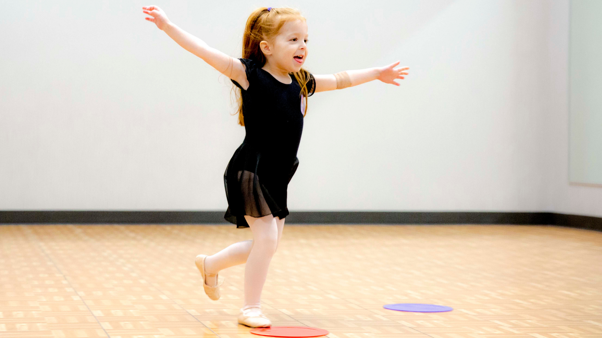 A preschooler dancing to shapes and colors to help with child development